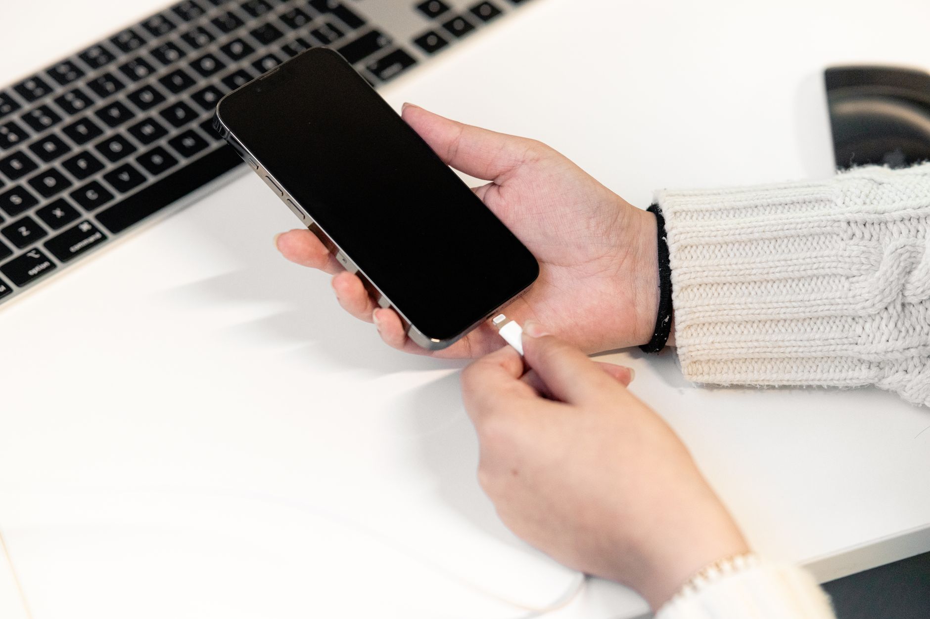 Smartphone plugged into a laptop USB port for tethering, cable visible