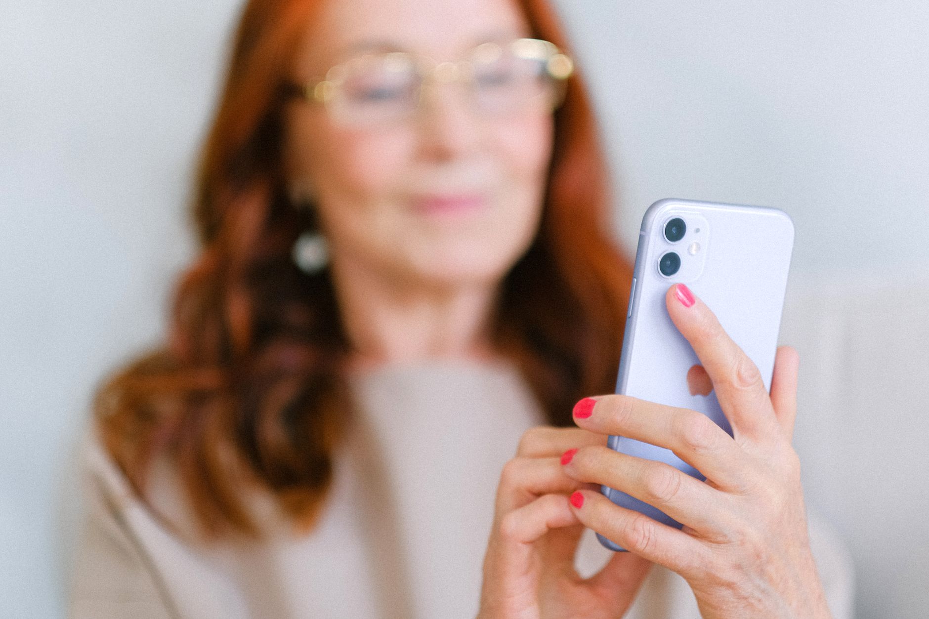 a senior woman looking at her smartphone with a worried expression while a pop-up message appears